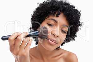 Teenager precisely applying powder with her black brush