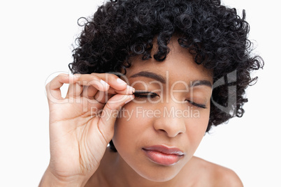 Young brunette placing false eyelashes