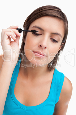 Young woman almost closing her eyes while applying mascara