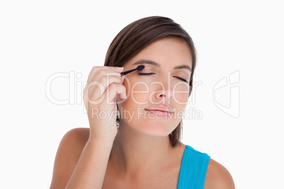 Teenager applying eyeshadow in a concentrated way