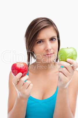 Serious teenage girl holding a green and a red apple