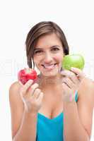 Smiling young woman holding two apples