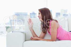 Smiling teenager saying hello with a wave of hand in front of he