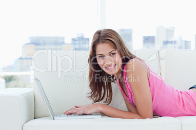 Young woman looking at the camera while writing something on her