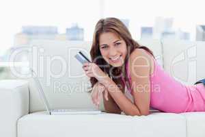 Young smiling woman lying on a comfortable sofa in front of her