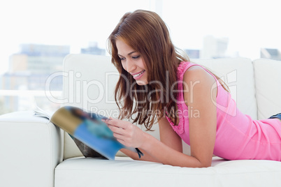 Teenager reading a review while lying on the couch
