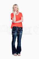 Thoughtful teenager standing upright with her fingers on chin