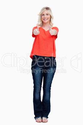 Smiling fair-haired teenager proudly showing her thumbs up