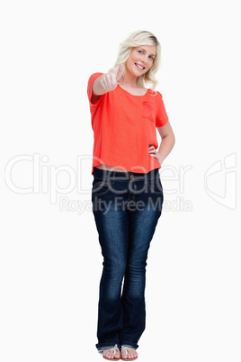 Smiling teenager tiltiing her head while showing her thumbs up
