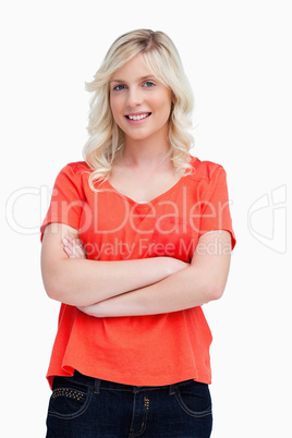 Smiling teenager crossing her arms against a white background