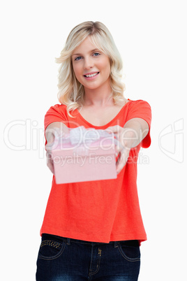 Happy young woman holding her birthday gift in front of her
