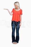 Smiling teenager standing upright with her hand palm up