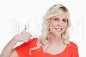 Smiling young blonde woman putting her thumbs up in agreement