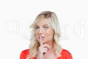 Young attractive woman telling to be quiet through a hand sign