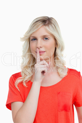 Beautiful woman looking at the camera while telling to be quiet