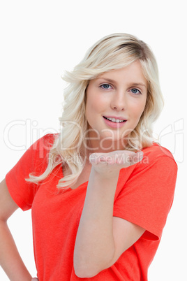 Young smiling woman sending an air kiss