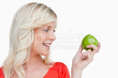 Young blonde woman looking on the side while holding a green app