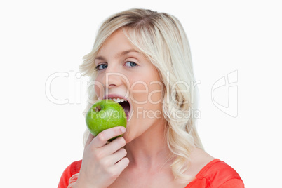 Attractive woman eating a delicious green apple