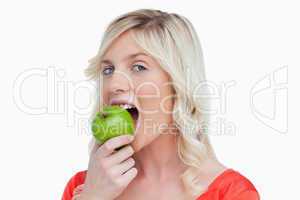 Attractive woman eating a delicious green apple