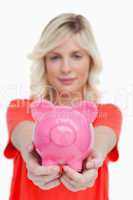 Pink piggy bank held by a young woman