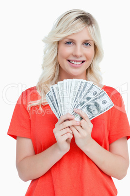 Young attractive woman holding dollar notes in a fan shape