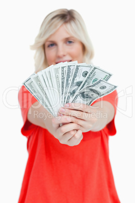 A fan of dollar notes held by a woman