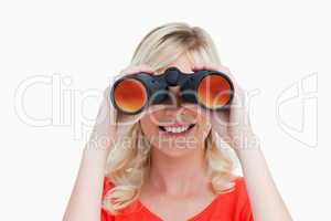 Blonde woman looking through binoculars