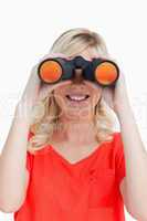 Smiling woman looking through binoculars