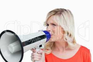 Young blonde woman speaking into a megaphone