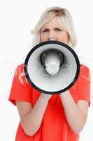 Woman looking upset while speaking into a megaphone
