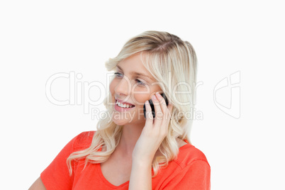 Smiling woman talking on a mobile phone while looking on the sid