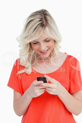 Smiling woman sending a text with her mobile phone