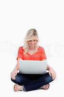 Attractive fair-haired woman sitting cross-legged with her hands