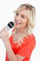 Smiling woman singing with a microphone