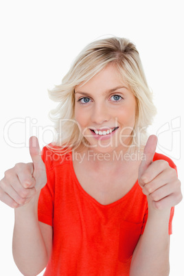 Teenage girl showing her thumbs up and a beaming smile