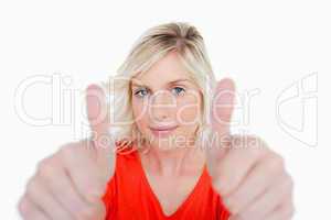 Smiling blonde woman putting her thumbs up