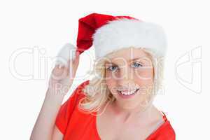 Young woman holding the pompom of her Christmas hat