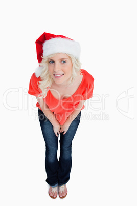 Fair-haired woman wearing the Santa Claus hat while leaning forw