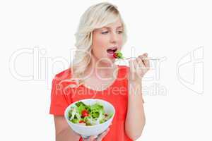 Fresh salad eaten by a young blonde woman