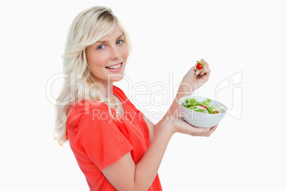 Side view of a young woman showing a great smile while eating sa