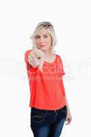 Young woman almost smiling while pointing her finger