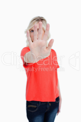 Young blonde woman making the stop sign with her hand