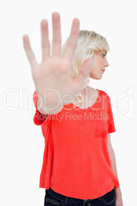 Young woman making the stop sign with hand while leaning her hea
