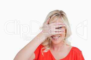 Young woman trying to see through her fingers placed in front of