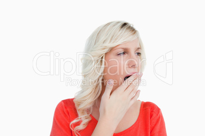 Young blonde woman looking on the side while yawning