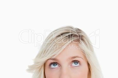 Upper part of the face of a blonde woman looking up