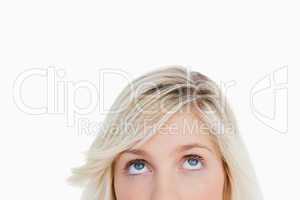Upper part of the face of a blonde woman looking up