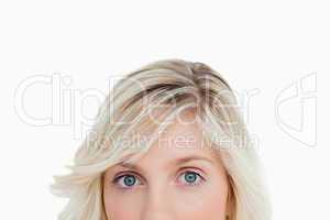 Upper part of a blonde woman's face looking straight at the came