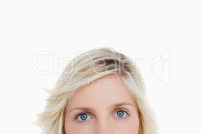 Upper part of a blonde woman face looking in front of her