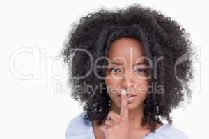 Young woman with curly hairstyle telling to be quiet